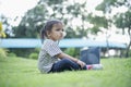 Happy asian family picnic. Daughters playing mobile phones and laptops having fun together while sitting alone on sunny day Royalty Free Stock Photo