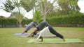 Happy asian family playing with children doing yoga exercises on grass in the park at the day time Royalty Free Stock Photo