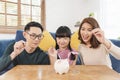 Happy Asian family saving money in piggy bank pig. investment for future concept Royalty Free Stock Photo