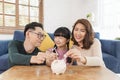 Happy Asian family saving money in piggy bank pig. investment for future concept Royalty Free Stock Photo