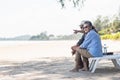 Happy Asian family, senior couple sitting on chairs with backs on beach travel vacation talking together Royalty Free Stock Photo