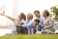 Happy asian family sitting on grass enjoying good time at dusk