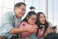 Happy asian family sitting on sofa and playing video games with their daughter down syndrome child in living room at morning time Royalty Free Stock Photo