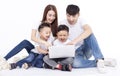 Happy Asian family sitting on white floor and using the laptop Royalty Free Stock Photo