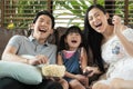 Happy Asian family spending time by watching tv together on sofa in living room. family and home concept. Royalty Free Stock Photo