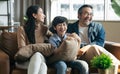 Happy Asian family spending time by watching tv together on sofa in living room. family and home concept. Royalty Free Stock Photo