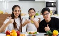 A happy Asian family spends lunch, vegetables, fruit, and dates at the table in their home. Cute little daughter having fun Royalty Free Stock Photo