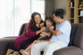 Happy Asian family time playing with their cat in the living room on the couch or sofa at home Royalty Free Stock Photo