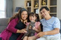 Happy Asian family time playing with their cat in the living room on the couch or sofa at home Royalty Free Stock Photo