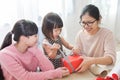 Happy Asian family unwrapping a gift box.