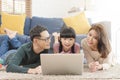 Happy Asian family using computer laptop together on sofa at home living room Royalty Free Stock Photo