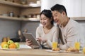 Happy asian family using digital tablet while having breakfast Royalty Free Stock Photo