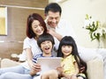 Happy asian family using digital tablet together Royalty Free Stock Photo