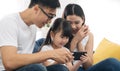 Happy Asian family using phone for playing game or watching movies family and home lifestyle concept. Royalty Free Stock Photo