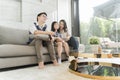 Happy asian family watching tv together on sofa in living room. family and home concept. Royalty Free Stock Photo