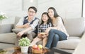 Happy asian family watching tv together on sofa in living room. family and home concept. Royalty Free Stock Photo