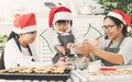 Happy Asian family wear Santa hats preparing the dough, bake coo