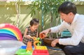 Happy Asian father and daughter having fun playing with water table at home, Wet Pouring Montessori Preschool Practical Life