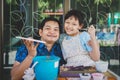 Happy asian Father `s day.Funny smiling father and her daughter painting and drawing with watercolor Royalty Free Stock Photo