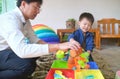 Happy Asian father and son having fun playing with water table at home, Wet Pouring Montessori Preschool Practical Life Activities