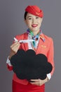 happy asian female air hostess showing blank cloud shape board