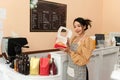 Happy asian female baker holding basket of bread, working at her bakery store. Middle aged female entrepreneur selling homemade Royalty Free Stock Photo