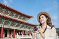 Happy asian female traveler photographing temples at Asia