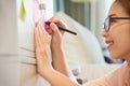 Asian Female writing on post it notes. Royalty Free Stock Photo