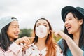 Happy Asian friends having fun chewing bubble gum outdoor - Young people playing and laughing together Royalty Free Stock Photo