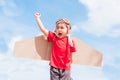 Kid little boy smile wear pilot hat play with toy airplane wing flying