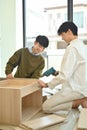 Happy asian gay couple talking and assembling furniture at their new home. LGBTQ, relocation and real estate Royalty Free Stock Photo