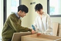 Happy asian gay couple talking and assembling furniture at their new home. LGBTQ, relocation and real estate Royalty Free Stock Photo