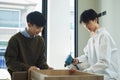 Happy asian gay couple using electric drill tool to assembling furniture in their new home Royalty Free Stock Photo