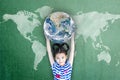 Happy Asian girl child student raising globe on school chalkboard for world literacy and gender equality concept