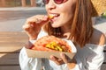 Asian girl eating taco outside. Mexican fastfood cuisine. Tasty and spicy snack in park