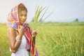 Happy Asian girl enjoy in green rice field, countryside of Thailand at sunset Royalty Free Stock Photo