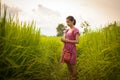 Happy Asian girl enjoy in green rice field, countryside of Thailand at sunset Royalty Free Stock Photo