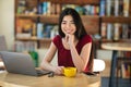 Happy asian girl enjoying coffee during work on laptop computer in cafe Royalty Free Stock Photo