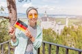 Asian traveller girl eats crispy pretzel in the background of the legendary Neuschwanstein castle. Tourism in Bavaria