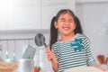 Happy girl having fun preparing pizza dough in kitchen and smile for funny child activity concept Royalty Free Stock Photo