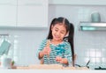 Happy girl having fun preparing pizza dough in kitchen and smile for funny child activity concept Royalty Free Stock Photo