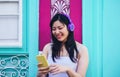 Happy Asian girl listening to music with headphones outdoor - Young Chinese woman playing her favorite playlist music Royalty Free Stock Photo