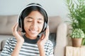 Happy Asian girl is music while sitting in the living room with closed eyes, Close-up expression on the child face and smile