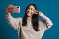 Happy asian girl showing peace sign while taking selfie on smartphone Royalty Free Stock Photo