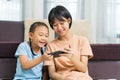 Happy Asian girl with sister play on the smart phone together Royalty Free Stock Photo