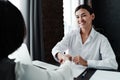 Happy asian girl sitting at table shaking hands with woman smiling for good job interview Royalty Free Stock Photo