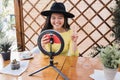 Happy asian girl streaming online using influencer led and mobile phone cam at bar restauran - Focus on face Royalty Free Stock Photo