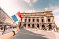 Asian girl traveler with french flag near the main Facade of the Opera Garnier in the historic building of the Academy of Royalty Free Stock Photo