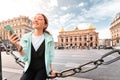 Asian girl traveler with phone near the main Facade of the Opera Garnier in the historic building of the Academy of music of Royalty Free Stock Photo