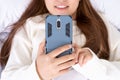 Happy Asian girl using a mobile phone lying on the bed at home. Social and technology concept Royalty Free Stock Photo